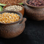 different kinds of bean seeds, lentil, peas in dishes on a dark background
